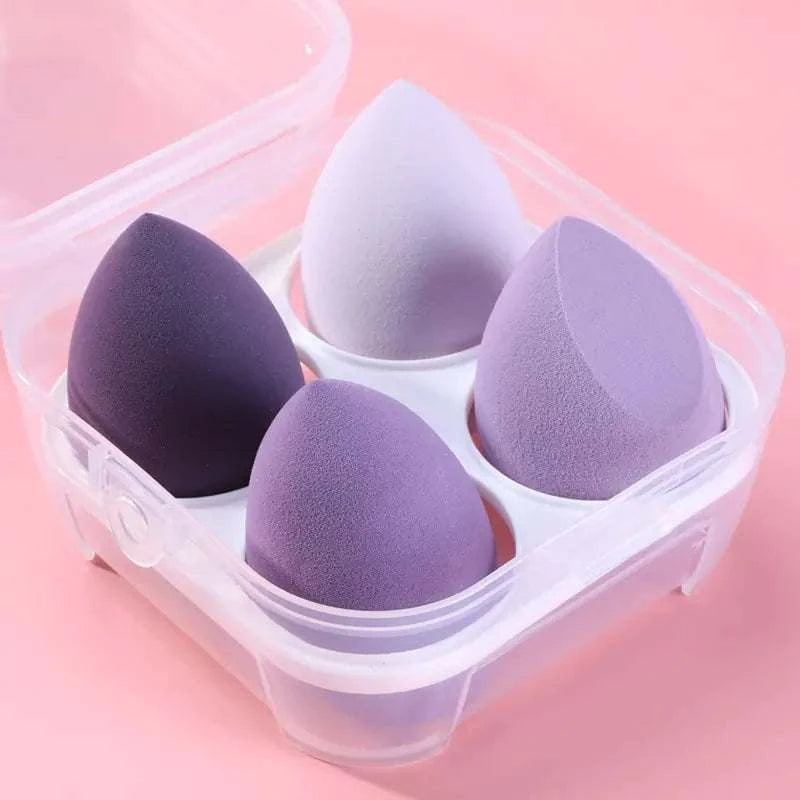 Set of 4 bevel cut purple makeup sponges in transparent case for flawless blending and foundation application